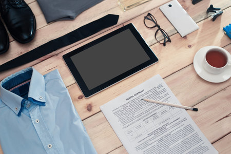 Rental contract and business accessories on wooden table.