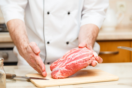 Cook men show how cuts a piece of meat. Close upの写真素材