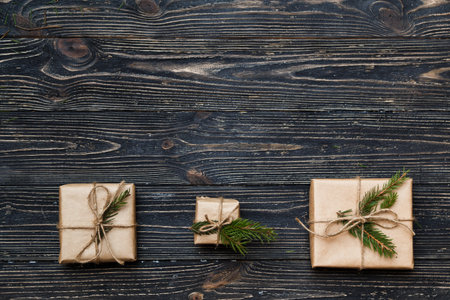 Three Vintage gift boxes with spruce branches on wooden background with copy space