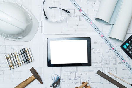 Construction blueprints with tools and tablet, top view