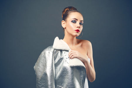 Young woman wearing futuristic silver fashionly jacketの写真素材
