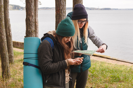 Two young tourist determine the route map and compass.の写真素材