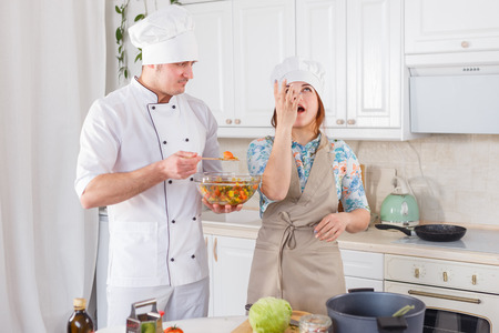 Funny senior chef cooks a tasting salad.の写真素材