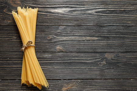 Banch of spaghetti on dark wooden table. Top viewの写真素材