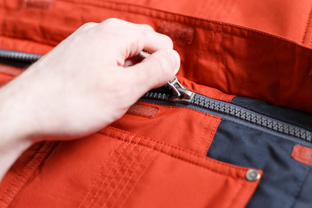 Part of a zipper with a lock on red clothの写真素材