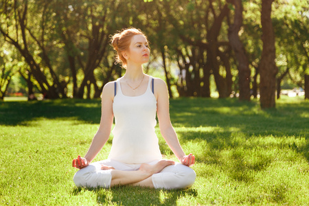 Young girl in lotus pose in the parkの写真素材