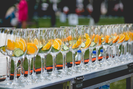 A row of glasses filled with ingredients for cucumber lemonade.の写真素材