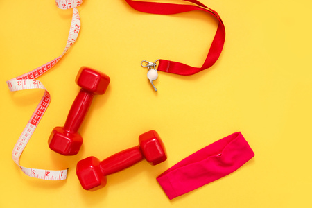 Two red dumbbells, tape measure and whistle.の写真素材