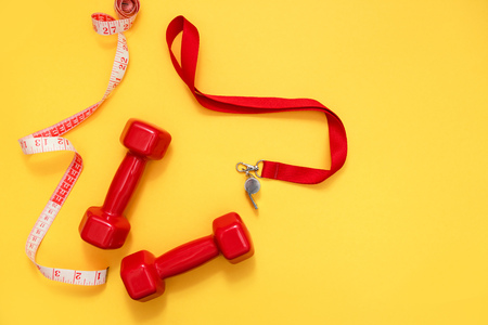 Two red dumbbells, tape measure and whistle.の写真素材