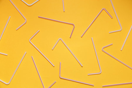 Drinking straws for party on yellow background. Top view.の写真素材