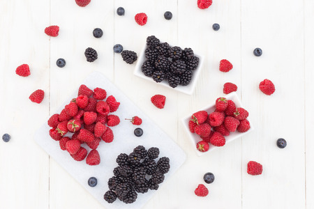 Blueberries, raspberries and blackberries on white backgroundの写真素材