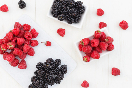 raspberries and blackberries white wooden backgroundの写真素材