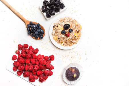 bowl of corn flakes with berries on white background.の写真素材