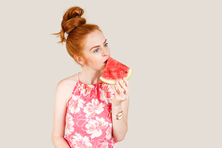 Joyful young woman holding slice of watermelonの写真素材