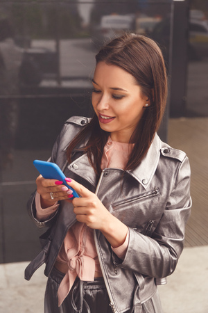 Young woman using her phone at the office buildingの写真素材