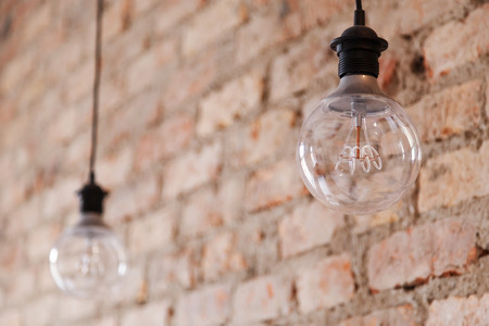 Decorative antique edison style light bulbs against brick wall backgroundの写真素材