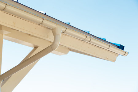 Gutter on house corner. Metal eave on roof