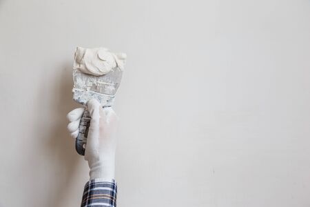 Worker in white gloves performs plastering of the walls of the roomの写真素材