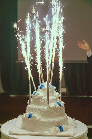 Beautiful three-layered wedding cake with fireworks.の写真素材