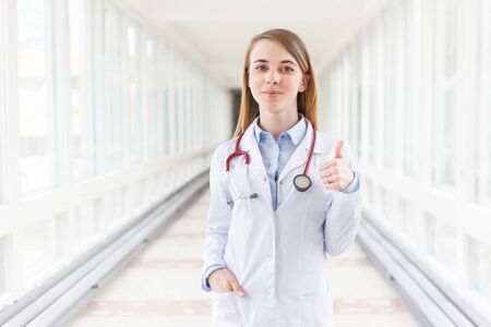 Young female doctor gesturing thumbs up.の写真素材