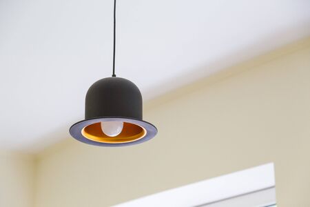 Modern black hanging lamp in shape of hatの写真素材