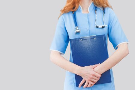 Female doctor holding blue folderの写真素材