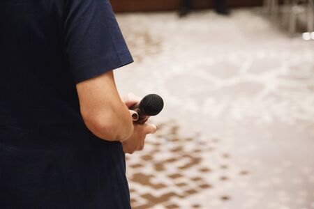 Microphone in speaker's hands at conference.の写真素材