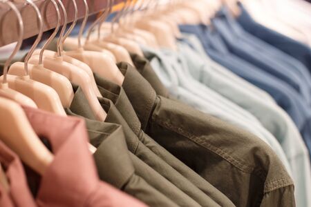 row of hangers with shirts in a store.の写真素材