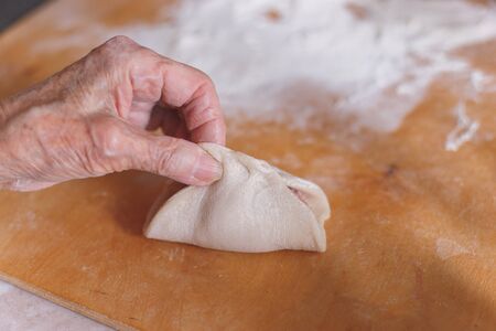 Aged woman is cooking manti. Traditional meat dish of the peoples of East Turkestan and Central Asiaの写真素材