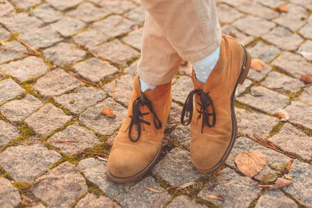 Women's legs in elegant autumn nubuck boots. At sunset in the cityの写真素材