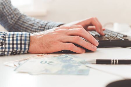Office work. Businessman work on computer with finances. Blurred background, film effect.の写真素材