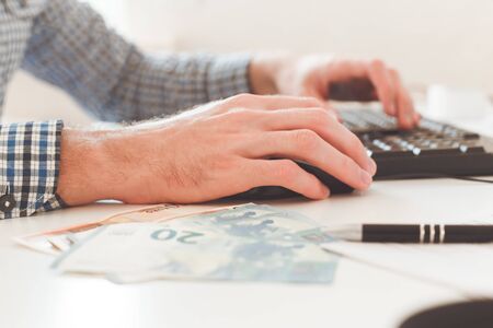Office work. Businessman work on computer with finances. Blurred background, film effectの写真素材