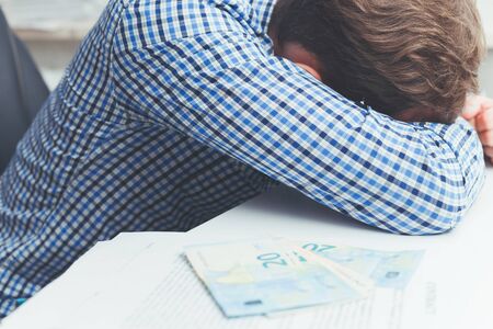 Overworked and tired businessman sleeping over at work on table in office.の写真素材