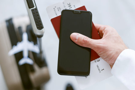 Electronic registration via smartphone to board the plane. A man with a suitcase holds a phone...