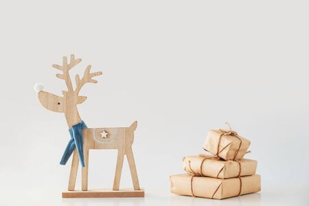 Toy deer carries a stack of gift boxes. Christmas and New Year concept. Isolated on white.の写真素材