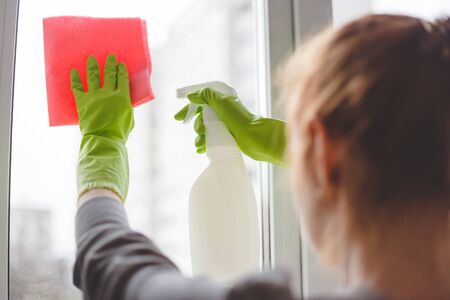 Women cleaning a window with spray and cloth. Close up viewの写真素材
