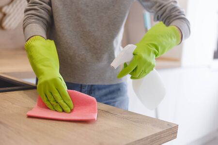 Close up woman cleaning kitchen using cleanser spray and cloth.の写真素材