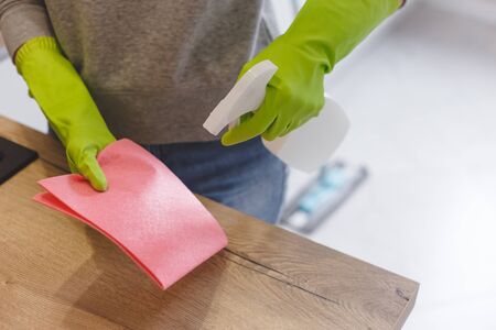 Close up woman cleaning kitchen using cleanser spray and cloth.の写真素材