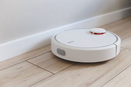 Home vacuum cleaning robot in action in living room.の写真素材