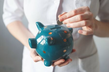 Doctor with piggy bank. Concept for financial checkup or saving for medical insurance costsの写真素材