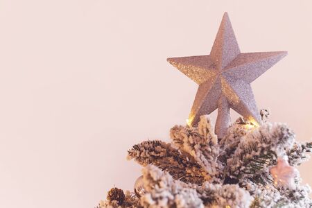 Christmas star on top of christmas tree. On pink background with copy spaceの写真素材