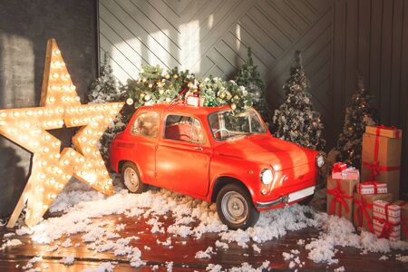 Retro car carrying Christmas tree. Fairytale, miniature scenery with snow and forest. Generic brandless wooden car.の写真素材