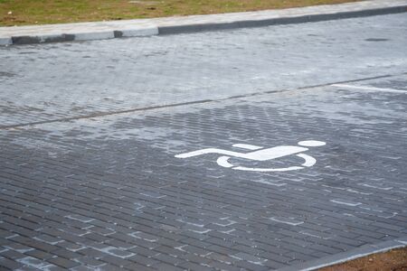Wheelchair disabled symbol parking permit sign painted on the street for handicapped person on concrete road, Outdoor place no people, no car on a grey concrete of the street.の写真素材