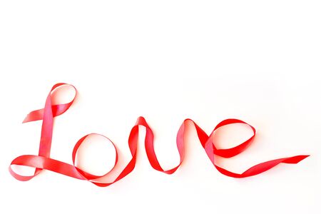 The word love written in red silk ribbon on a white background.Valentine's Day Concept, February 14thの写真素材