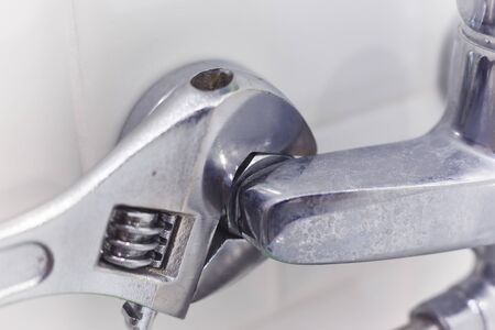 Plumber uses pipe wrench for service shower mixer tap.の写真素材