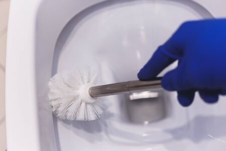 Toilet cleaning with brush. Hand in glovesの写真素材