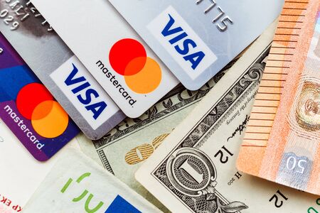 Minsk, Belarus - January 3, 2019: Pile of credit cards, Visa and MasterCard, credit, debit, electronic cards and cash moneyのeditorial素材