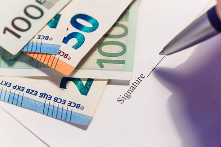 Signing a financial contract, employment agreement. Money and signature column.の写真素材