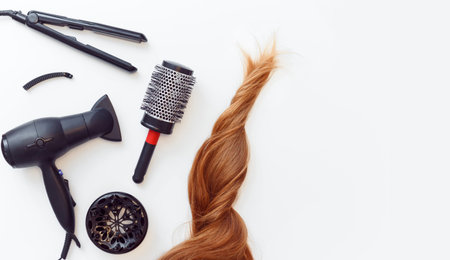 Set of tools dryer, iron and hair brush for hairstyle and red hair on white. Flat lay