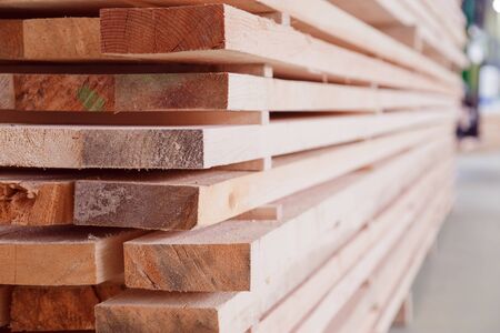 Warehouse or factory for sawing boards on sawmill indoors. Wood timber stack of wooden blanks construction material. Logging Industryの写真素材